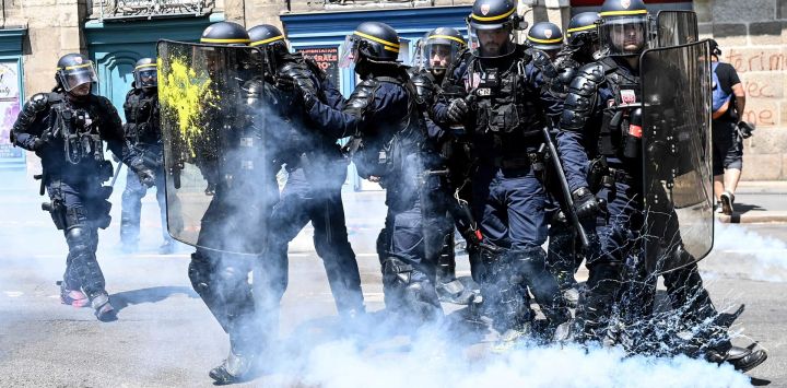 Gendarmes franceses de pie entre gases lacrimógenos durante una manifestación en el 14 º día de acción después de que el gobierno impulsó una reforma de las pensiones a través del parlamento sin votación, utilizando el artículo 49.3 de la constitución, en Nantes, oeste de Francia.