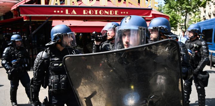 Gendarmes franceses frente al restaurante La Rotonde durante una manifestación después de que el gobierno impulsara una reforma de las pensiones a través del parlamento sin votación, utilizando el artículo 49.3 de la constitución, en París.