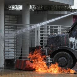 Un vehículo antidisturbios es alcanzado por un cóctel molotov durante una protesta en conmemoración del día del estudiante caído en Bogotá, Colombia. | Foto:Juan Pablo Pino / AFP