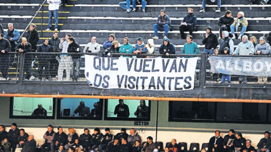 Football fans hold up a banner calling for away supporters to be re-admitted to matches in Argentina.