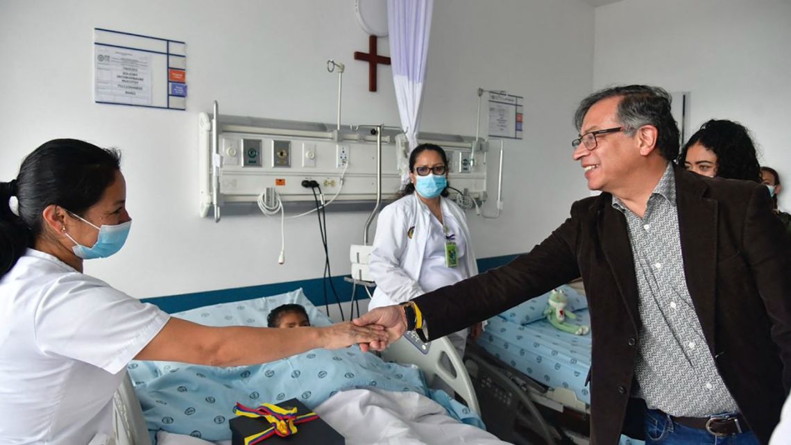 This handout picture released by the Colombian Presidency shows Colombian President Gustavo Petro (right) greeting a nurse while visiting the four Indigenous children who were found alive after being lost for 40 days in the Colombian Amazon rainforest following a plane crash, at the Military Hospital in Bogotá on June 10, 2023.