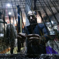 En esta fotografía un hombre trabaja en una fábrica de alfombras y esterillas de plástico reciclado en Sarmada, en la provincia noroccidental siria de Idlib. | Foto:AAREF WATAD / AFP