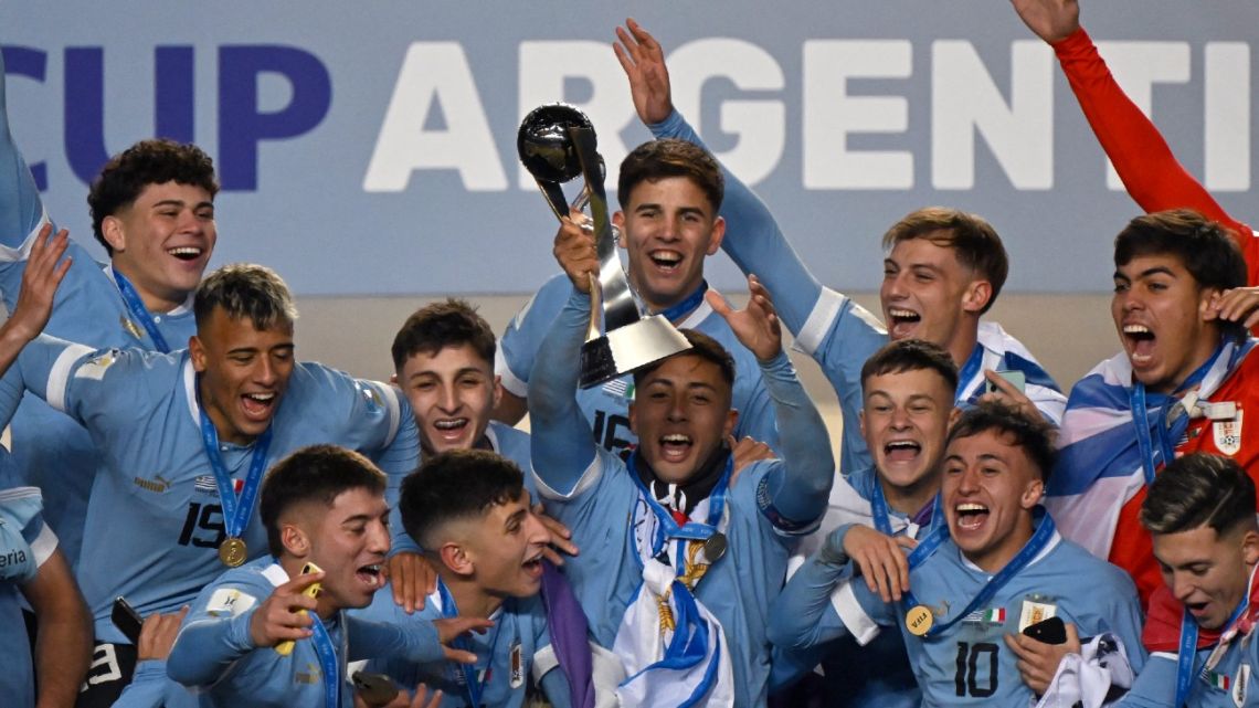 Uruguay's midfielder Fabricio Díaz holds the trophy along with his teammates after defeating Italy and winning the 2023 U20 World Cup at the Estadio Unico Diego Armando Maradona stadium in La Plata, Argentina, on June 11, 2023.