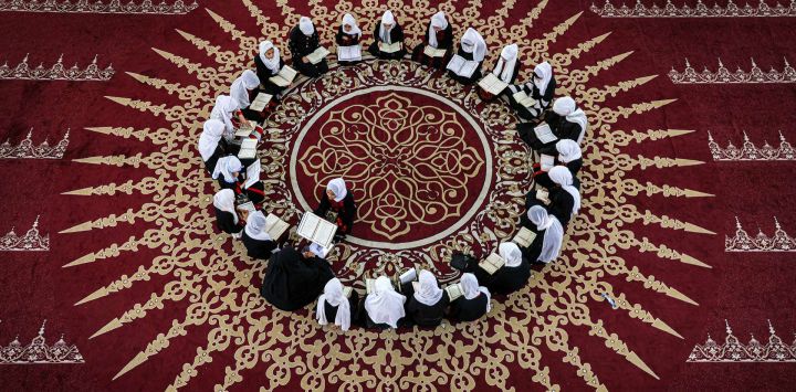 Niñas palestinas musulmanas sentadas en círculo en una clase de recitación del Corán, el libro sagrado del Islam, durante un campamento de verano en una mezquita de la ciudad de Gaza.