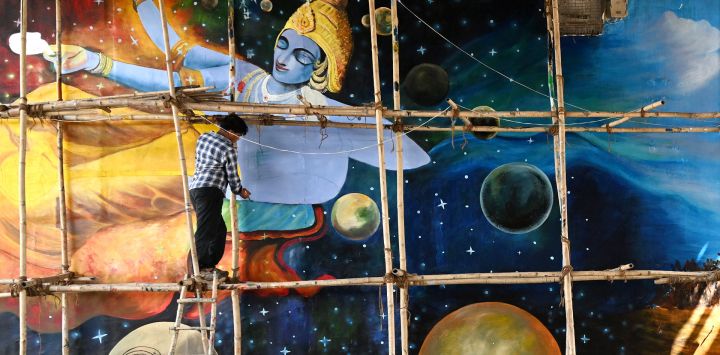 Un artista da los últimos retoques a un mural pintado bajo un puente en Nueva Delhi, India.