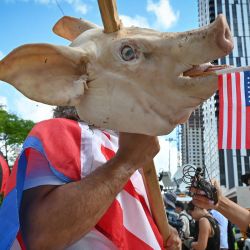 Osmany Estrada muestra su apoyo con una cabeza de cerdo en una estaca frente al Palacio de Justicia de los Estados Unidos Wilkie D. Ferguson Jr. antes de la comparecencia del expresidente Donald Trump en Miami, Florida. | Foto:Giorgio Viera / AFP