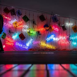 Un visitante pasa junto a "Topa", una instalación de neón de 2005 del artista estadounidense Jason Rhoades, expuesta en la sección Unlimited de la feria de arte moderno y contemporáneo Art Basel, en Basilea, Suiza. | Foto:FABRICE COFFRINI / AFP