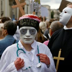 Una manifestante lleva una cinta en la cabeza con la inscripción "Cláusula de conciencia" mientras otra va vestida de clérigo durante una protesta contra la legislación sobre el aborto tras la reciente muerte de una mujer embarazada en marzo de 2023, en el centro de Varsovia, Polonia. | Foto:WOJTEK RADWANSKI / AFP