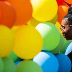 Una mujer camina junto a globos con los colores del arco iris durante el Festival del Orgullo de la Capital en Washington, DC. | Foto:ANDREW CABALLERO-REYNOLDS / AFP