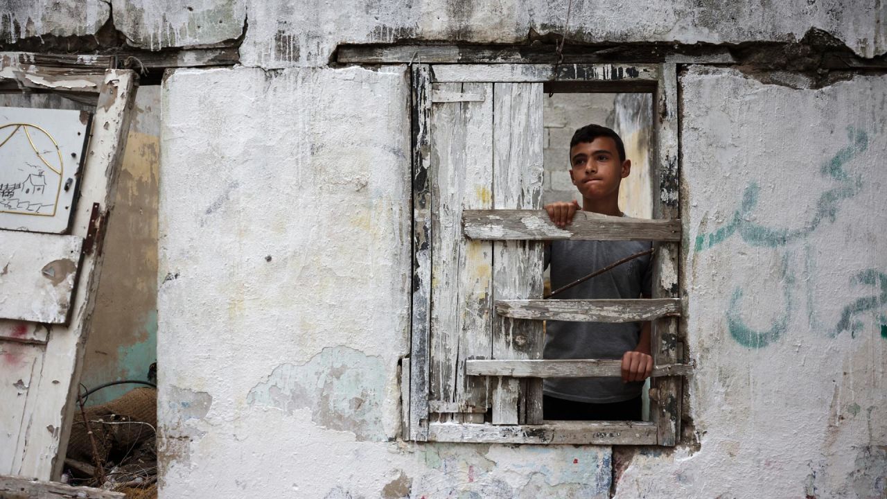 Un adolescente palestino se refugia dentro de una casa en ruinas durante la lluvia en la ciudad de Gaza. | Foto:MOHAMMED ABED / AFP