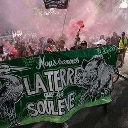 Manifestantes marchan detrás de una pancarta en la que se lee "somos la tierra que se levanta" durante una concentración de apoyo al movimiento ecologista "Les Soulevements de la Terre" (Los Levantamientos de la Tierra) en Nantes, oeste de Francia, para protestar contra la decisión del gobierno de disolver el movimiento. | Foto:LOIC VENANCE / AFP