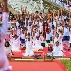 Practicantes participan en una sesión masiva de yoga organizada por la Oficina de la Alta Comisión de la India en la plaza de la Independencia de Colombo, Sri Lanka. | Foto:ISHARA S. KODIKARA / AFP