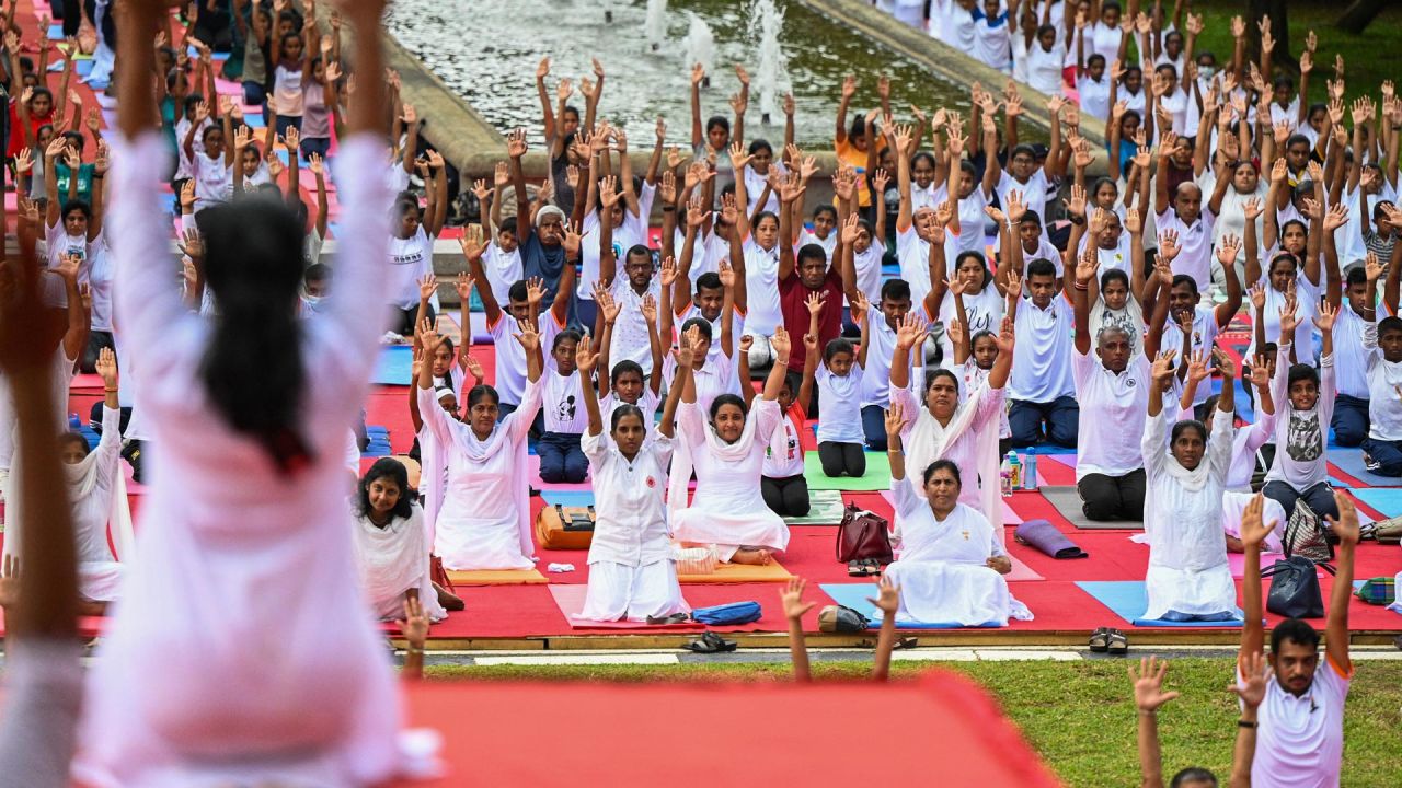 Practicantes participan en una sesión masiva de yoga organizada por la Oficina de la Alta Comisión de la India en la plaza de la Independencia de Colombo, Sri Lanka. | Foto:ISHARA S. KODIKARA / AFP