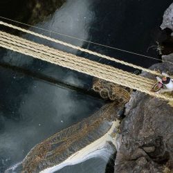 Vista aérea que muestra a personas de diferentes comunidades que participan en la renovación anual del puente de cuerda Q'eswachaka, mientras el antiguo se desploma en el río Apurímac, cerca de Huinchiri, departamento de Cusco, en el sur de Perú. | Foto:Christian Sierra / AFP