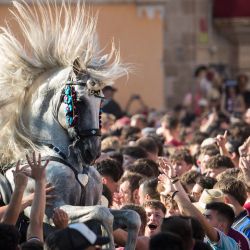Un caballo se encabrita entre la multitud durante el "Caragol des Born", un encuentro multitudinario de caballos y personas que se arremolinan al ritmo de la música durante la tradicional fiesta de San Juan en la localidad de Ciutadella, en la isla balear de Menorca, en la víspera del día de San Juan. | Foto:JAIME REINA / AFP