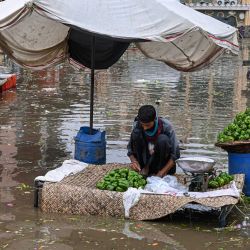Un vendedor clasifica pimientos en un mercado inundado tras las fuertes lluvias caídas en Lahore, Pakistán. | Foto:ARIF ALI / AFP
