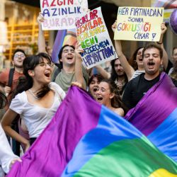 Miembros de la comunidad LGBTQ y simpatizantes sostienen banderas con los colores del arco iris y gritan consignas durante la Marcha del Orgullo no autorizada en Estambul, Turquía. | Foto:YASIN AKGUL / AFP
