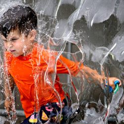 Un niño juega en la fuente de agua de Yards Park en Washington, DC, mientras una ola de calor se instala en la zona. | Foto:JIM WATSON / AFP