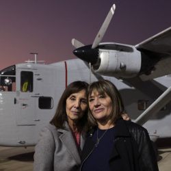 Cecilia De Vicenti and Mabel Careaga, the daughters of Azucena Villaflor and Esther Ballestrino de Careaga, founder members of the Madres de Plaza de Mayo- human rights organisation, pose for a picture next to the Short SC-7 Skyvan aircraft used during the last 1976-1983 military dictatorship, on the tarmac of the Jorge Newbery International Airport in Buenos Aires, on June 26, 2023.