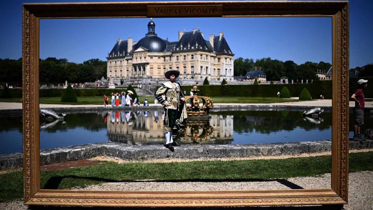 Un hombre vestido con un traje del siglo XVII posa mientras participa en "La grande journee des costumés", un evento histórico que reúne a cientos de personas en el castillo de Vaux-le-Vicomte (al fondo), en Maincy, a unos 50 kilómetros al sureste de París. | Foto:CHRISTOPHE ARCHAMBAULT / AFP