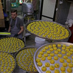 Miembros de la familia al-Jaabary preparan dulces tradicionales en su panadería antes de la fiesta musulmana de Eid al-Adha, en la ciudad de Hebrón, en la Cisjordania ocupada. | Foto:HAZEM BADER / AFP