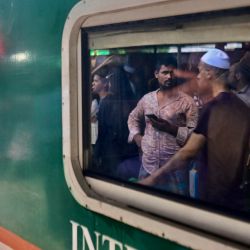 Una mujer mira desde un tren en la estación de tren del aeropuerto de Dhaka en Dhaka, mientras la gente viaja a sus ciudades de origen antes del festival musulmán de Eid al-Adha o el "Festival del Sacrificio". | Foto:MUNIR UZ ZAMAN / AFP