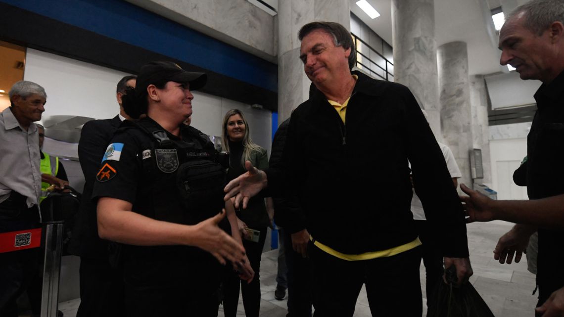 Former Brazilian President Jair Bolsonaro greets a military police officer upon arrival at the Santos Dumont Airport in Rio de Janeiro, Brazil, on June 29, 2023.
