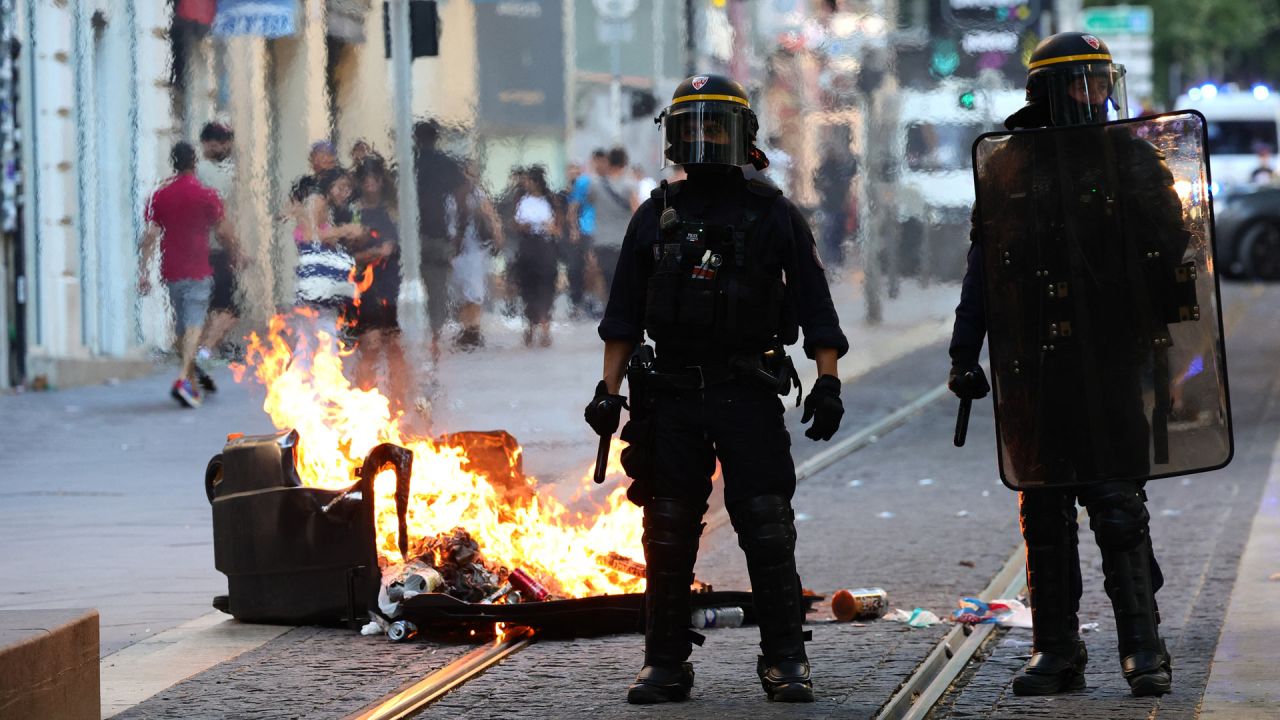 Agentes de la policía antidisturbios francesa montan guardia junto a un contenedor de basura quemado durante una manifestación contra la policía en Marsella, sur de Francia. | Foto:CLEMENT MAHOUDEAU / AFP