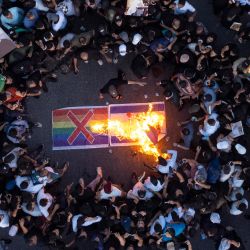 Simpatizantes del movimiento sadrista iraquí queman una bandera israelí y una bandera arco iris durante una manifestación en Basora, en medio de las protestas contra la quema de un Corán frente a una mezquita de Estocolmo que indignó a musulmanes de todo el mundo. | Foto:Hussein Faleh / AFP