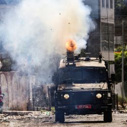Un vehículo blindado israelí dispara gas lacrimógeno durante una operación militar en curso en la ciudad de Yenín, en la Cisjordania ocupada. | Foto:RONALDO SCHEMIDT / AFP