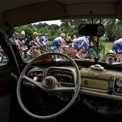 El pelotón de ciclistas pasa junto a un vehículo clásico de colección durante la 4ª etapa de la 110ª edición de la carrera ciclista Tour de Francia, 182 km entre Dax y Nogaro, en el suroeste de Francia. | Foto:MARCO BERTORELLO / AFP