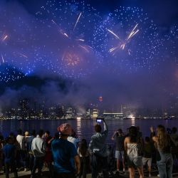Un grupo de personas observa la explosión de fuegos artificiales sobre el horizonte de Manhattan durante el espectáculo pirotécnico del Día de la Independencia de Macy's en Nueva York. | Foto:Adam Gray/ AFP