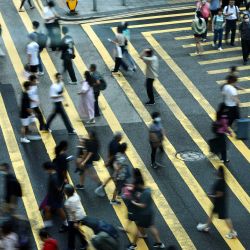 Varias personas cruzan una calle en Central, un centro financiero de Hong Kong. | Foto:MAY JAMES / AFP