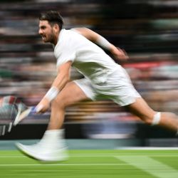 El británico Cameron Norrie devuelve la pelota al checo Tomas Machac durante su partido de tenis individual masculino de los Campeonatos de Wimbledon 2023 en The All England Tennis Club en Wimbledon, suroeste de Londres. | Foto:SEBASTIEN BOZON / AFP