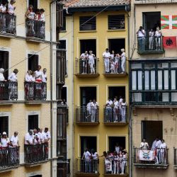 Los vecinos observan desde su balcón cómo los participantes celebran durante el "Chupinazo" la ceremonia de apertura para marcar el inicio de las fiestas taurinas de San Fermín frente al Ayuntamiento de Pamplona, en el norte de España. | Foto:ANDER GILLENEA / AFP