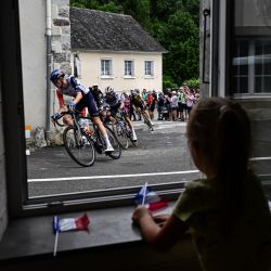 Una niña mira por una ventana mientras el pelotón de ciclistas pasa durante la 5ª etapa de la 110ª edición del Tour de Francia de ciclismo, 163 km entre Pau y Laruns, en las montañas de los Pirineos en el suroeste de Francia. | Foto:MARCO BERTORELLO / AFP