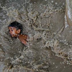Un niño juega en una zona residencial inundada cerca de las orillas del río Yamuna después de que se desbordara debido a las lluvias monzónicas, en Nueva Delhi. Foto de Arun SANKAR / AFP | Foto:AFP