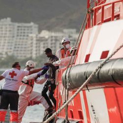 Los trabajadores de la Cruz Roja ayudan a los migrantes a desembarcar de un buque de Salvamento Marítimo español en el puerto de Arguineguín, en la isla canaria de Gran Canaria. Foto DESIREE MARTIN / AFP | Foto:AFP