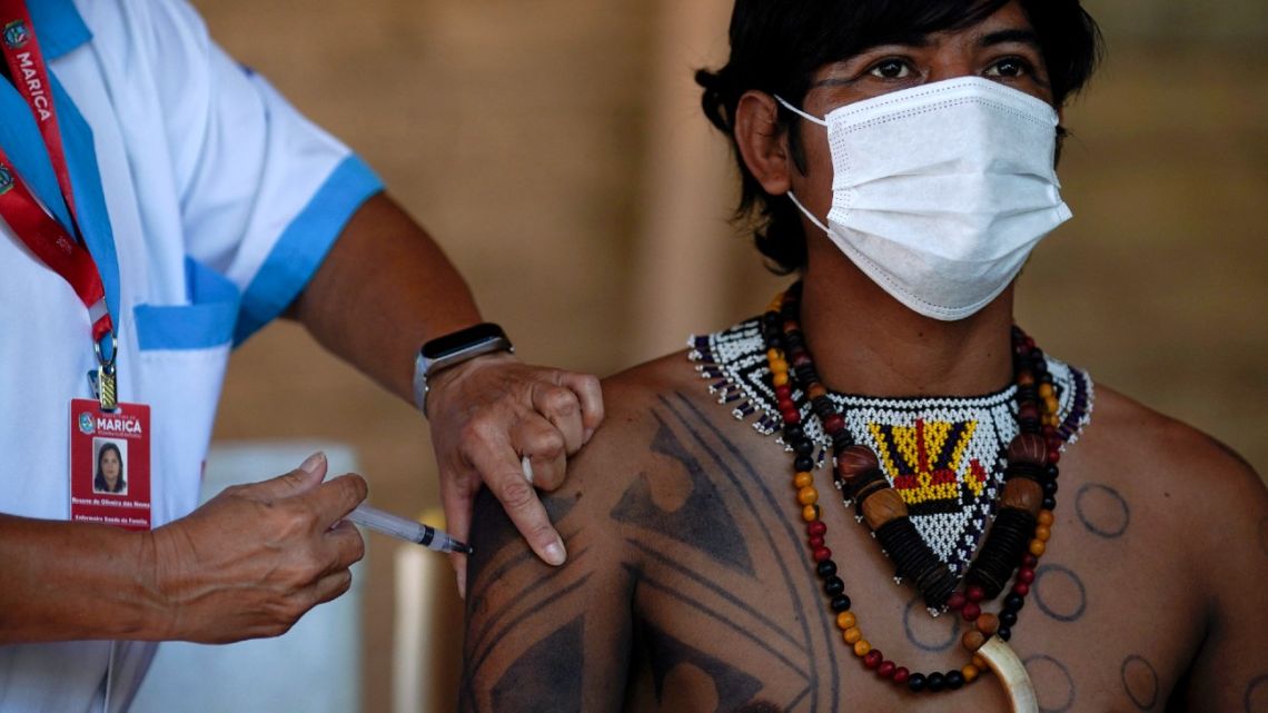 Guarani indigenous man is inoculated with the Sinovac Biotech's CoronaVac vaccine against COVID-19 at the Sao Mata Verde Bonita tribe camp, in Guarani indigenous land, in the city of Marica, Rio de Janeiro state, Brazil, on January 20, 2021, amid the new coronavirus pandemic.