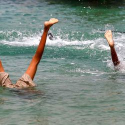 Los niños realizan volteretas hacia atrás bajo el agua en el Mar Rojo cerca del puerto de Ras Issa, en Yemen. Foto MOHAMMED HUWAIS / AFP  | Foto:AFP