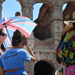 Los turistas se protegen del sol con sombrillas cerca del Coliseo en Roma, cuando Italia se ve afectada por una ola de calor. Foto de Alberto PIZZOLI / AFP | Foto:AFP
