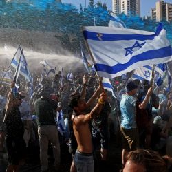 Las fuerzas de seguridad israelíes utilizan un cañón de agua para dispersar a los manifestantes que bloquean la entrada de la Knesset, el Parlamento de Israel, en Jerusalén, en medio de una ola de meses de protestas contra la reforma judicial prevista por el gobierno. | Foto:RONALDO SCHEMIDT / AFP
