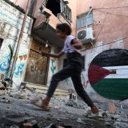 Un joven camina entre los escombros de un edificio tras una redada militar israelí en busca de palestinos buscados en el campo de refugiados de Nur Shams, al este de Tulkarm, en la Cisjordania ocupada. | Foto:JAAFAR ASHTIYEH / AFP