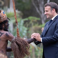 El presidente francés, Emmanuel Macron, le da la mano a una bailarina tradicional durante una ceremonia tradicional en su honor en Touho, al norte de Nueva Caledonia. | Foto:RAPHAEL LAFARGUE / POOL / AFP