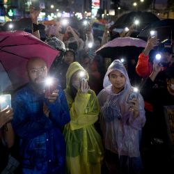 Los manifestantes a favor de la democracia sostienen sus teléfonos durante una manifestación en apoyo del Partido Move Forward en Bangkok después de que el parlamento de Tailandia bloqueara la nominación a primer ministro del líder del partido, Pita Limjaroenrat. | Foto:JACK TAYLOR / AFP