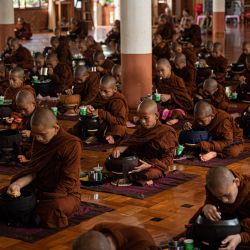 Monjes budistas novicios almuerzan en un monasterio de Yangón, Myanmar. | Foto:Sai Aung Main / AFP