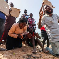 Migrantes de África, varados a la orilla del mar en la frontera entre Libia y Túnez en Ras Jedir, reaccionan ante los periodistas. | Foto:Mahmud Turkia / AFP