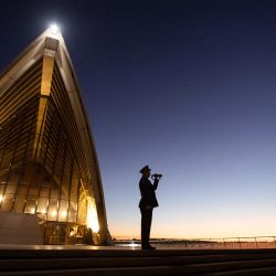 Esta foto del folleto tomada y publicada por la Ópera de Sídney muestra a un corneta solitario tocando The Last Post en los escalones de la Ópera de Sídney. | Foto:Daniel Boud / Sydney Opera House / AFP