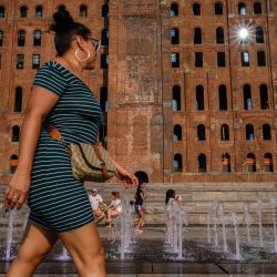 Una mujer camina frente a una fuente de agua en Nueva York. | Foto:Ed JONES / AFP