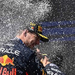 El piloto holandés de Winner Red Bull Racing, Max Verstappen, rocía champán mientras celebra en el podio después de ganar el Gran Premio de Bélgica de Fórmula Uno en el circuito de Spa-Francorchamps en Spa. | Foto:JOHN THYS / AFP
